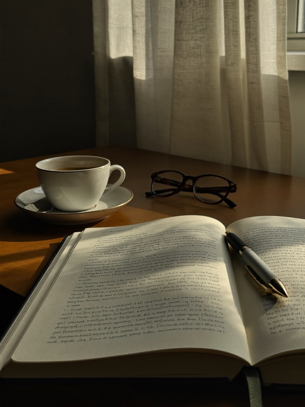 Sample image: a calm, warmly lit moment of reflection, an open journal and coffee by a sunlit window. Swappable placeholder.